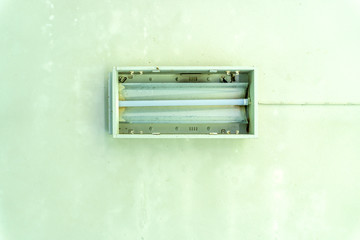 Fluorescent , Neon lamp with old defective condition hang in white concrete ceiling, copy space
