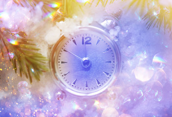Obraz na płótnie Canvas Christmas and New Year holidays background with clock. Glitter lights backdrop. Winter season. Text space. Closeup of Christmas-tree branch.