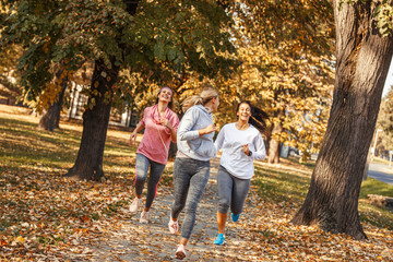 Fototapeta premium Group of female friends jogging at the city park.Autumn season.
