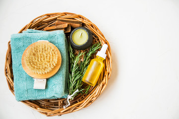 Natural spa skincare and beauty products. Rosemary herb, oil bottle, body brush and towel, top view of spa products with natural ingredients