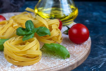 Ingredients for cooking Italian pasta. Pasta, basil, cheese, cherry tomatoes, olive oil, egg, yolk. On a light background. Copy space. 