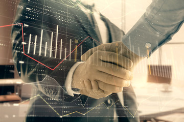 Multi exposure of financial graph on office background with two businessmen handshake. Concept of...