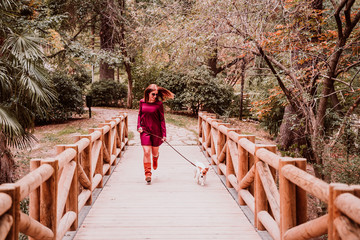 young woman and her cute jack russell dog walking in a park. Love for animals concept