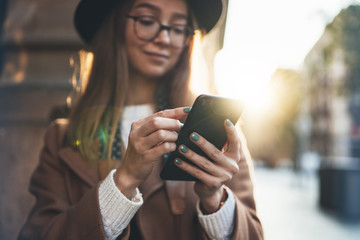 Woman holding in hands mobile phone. Close up technology smartphone online connect. Girl traveler in hat using gadget cellphone in europe sunlight city. Digital internet lifestyle mockup