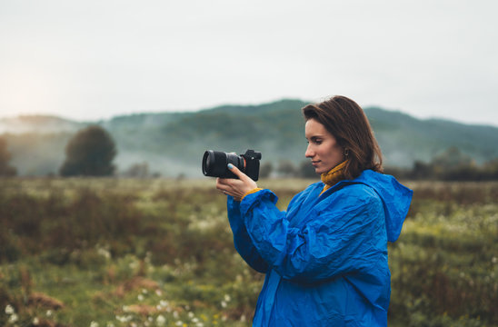 photographer tourist girl in blue raincoat photo camera take photography foggy mountain, traveler shoot autumn nature, video click on camera technology, journey landscape vacation concept free space
