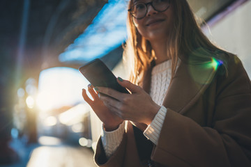 Woman holding in hands mobile phone on platform station. Close up technology smartphone online connect. Girl travel waiting train using gadget cellphone. Digital wifi internet lifestyle mockup