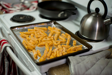 A baking sheet lined with foil, covered in frozen french fries, waiting to go in the oven