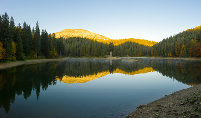 big lake in the middle of mountains during autumn