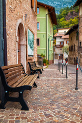 Plakat Old small stone street in Italy. City of Ranzo province of Trento. The background is in focus, the foreground is blurred.