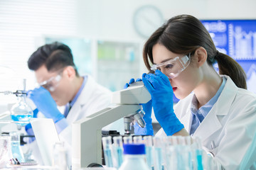 Asian scientist use microscope