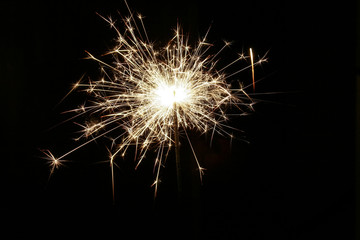 Closeup view of bright burning sparkler on a black background