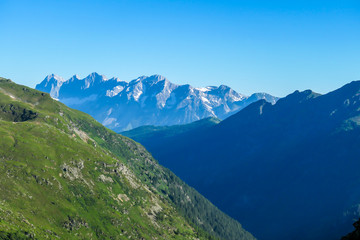 Obraz premium Massive mountain range of Schladming Alps, Austria. The slopes of Alps are steep, partially overgrown with green bushes. Dangerous mountain climbing.Clear and beautiful day. Endless mountain ranges,