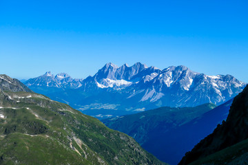Massive mountain range of Schladming Alps, Austria. The slopes of Alps are steep, partially overgrown with green bushes. Dangerous mountain climbing.Clear and beautiful day. Endless mountain ranges,