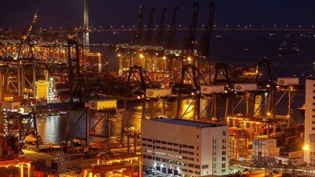 Timelapse illuminated Hong Kong harbour with gantry cranes