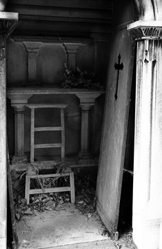 unhinged door and broken chair on loculus of the cemetery