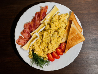 Omelet with bacon, tomatoes, cheese and toast on wooden background. Top view.