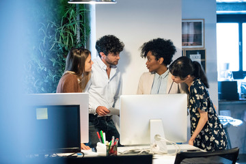 Businessman and businesswomen discussing with each other in office