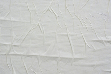 White sheet of crumpled paper glued to the wall.