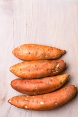 sweet potatoes on wooden background, copy space