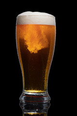 Glass of beer isolated on black background.