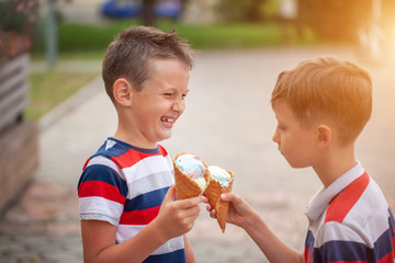 Two boys best friends eating ice cream outdoors.