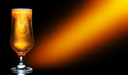 Glass of cold craft light beer on dark background..
