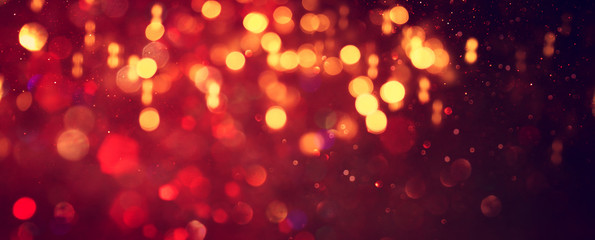 background of abstract red, gold and black glitter lights. defocused. banner