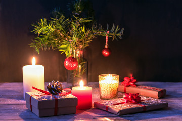 Christmas gifts, candles and fir twigs with toys, New Year concept, soft focus