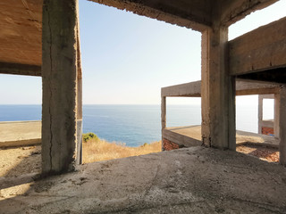 Concrete support of an unfinished house on the seashore, inside view of the sea. Real estate on the sea coast.