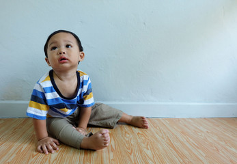 Happy little cute asian boy sat and looked innocent in the living room.