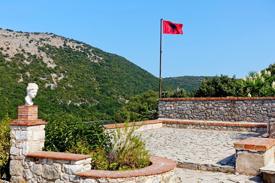 Flag of Albania over the ruins of the ancient Greek city of Butring