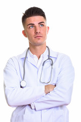 Fototapeta premium Studio shot of young handsome man doctor thinking with arms cros