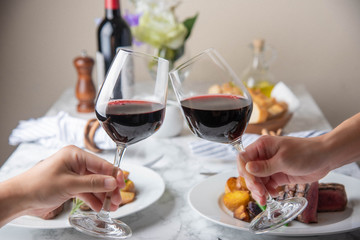 toasting with red wine at steak dinner