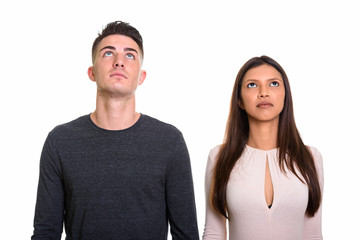 Studio shot of young couple looking up and thinking together