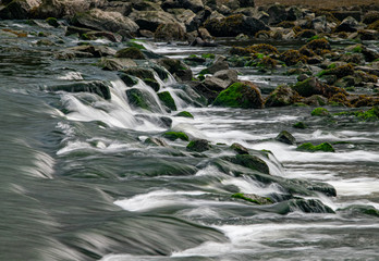 Long exposure as the River Meavy flows over rocks at Lopwell Weir, Plymouth, Devon