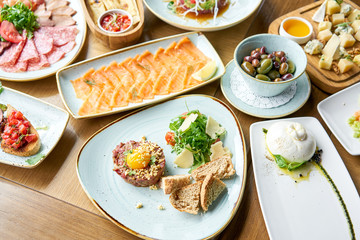 Beef tartar in the restaurant. Variety of dishes on the table. Various snacks and antipasti on the table. Restaurant menu. Italian cuisine