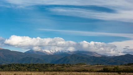 Fototapeta premium Autumn landscape, mountain with snow and colored forest.