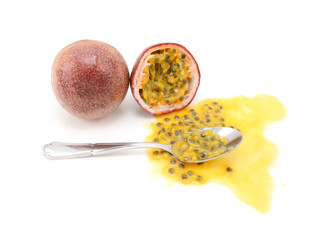 Whole passion fruit and half-eaten cross section with spoon