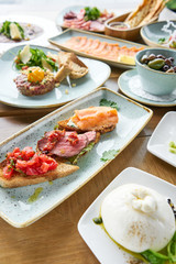 Bruschetta with beef, tomatoes and salmon.. Variety of dishes on the table. Various snacks and antipasti on the table. Restaurant menu. Italian cuisine