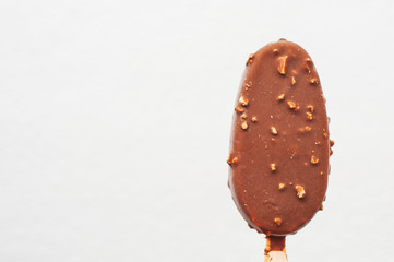 Ice cream on a stick. Chocolate ice cream with nuts on white background.