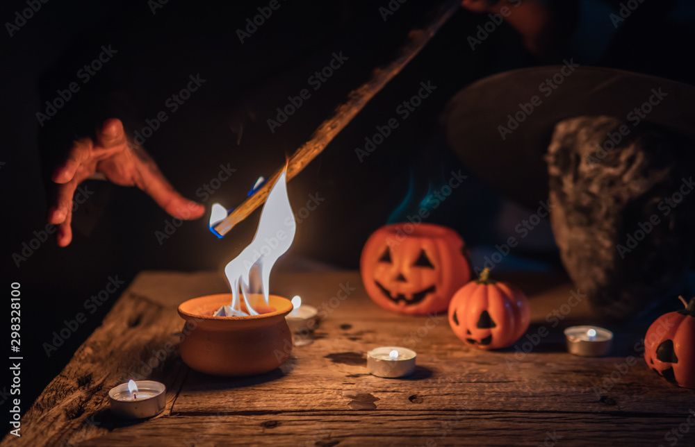 Wall mural witch doing curse and ceremony in the dark of halloween night on the table with candles, skull and w