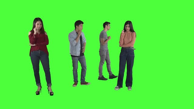 Group of thoughtful young people thinking something while walking back and forth in the studio. Shot in 4k resolution with green screen background