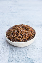 Cooked buckwheat in bowl on table.