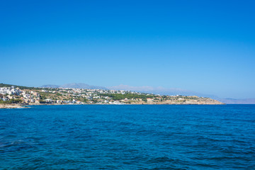 view from the sea to the Mediterranean city on the shore and the mountains. Greece, Crete, Rethymno.