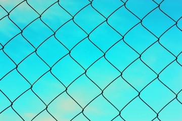 Fototapeta premium Black metal mesh on the background and blue sky