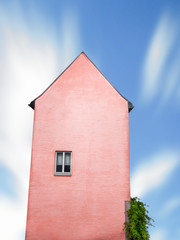 Pink house with just one window against ble sky