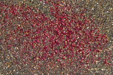 Sparkling red glitters on pebblestone road