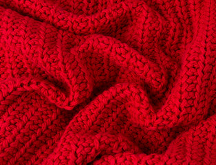 Texture of red knitted fabric close up. Wool knitwear