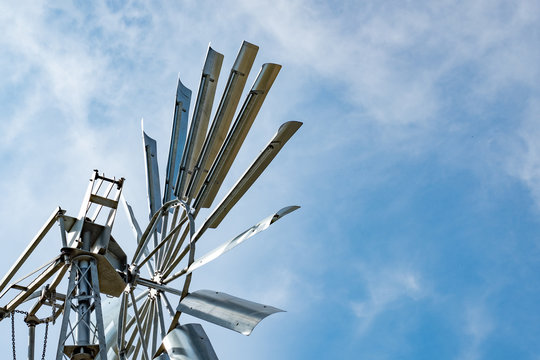 Detailed, abstract view of a newly installed, all metal renewable energy windmill showing some of the blades. Also used as a water pump.