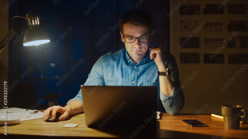 Poster professional man sitting at his desk in office studio working on a laptop in the evening. man analyz
